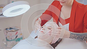 cleansing and rejuvenating treatments in beauty salon, aesthetician massaging female face