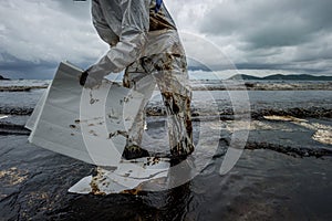 Cleanup crews fill bags with oiled sand and debris after a pipeline spilling oil into an