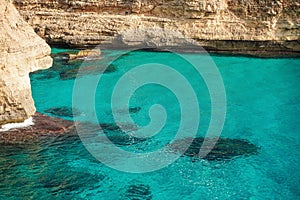 Clear blue green sea water, rocky cliffs around - nice sunny day at Ansa de s`Estri, Mallorca