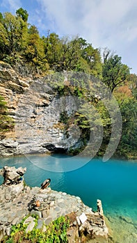 Clear blue lake against the backdrop of mountains in greenery