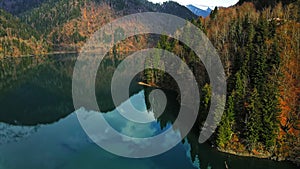 Clear blue mountain lake with reflection of clouds on the water. Drone view