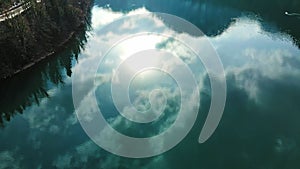 Clear blue mountain lake with reflection of clouds on the water. Drone view