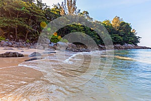 Clear blue sea and beach with palm trees. View from the sea to the Thailand beach, large stones on the shore and clean sand