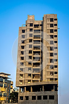 Clear blue sky behind two tall buildings in Sunlight , under construction in fast growing city of Pune, India