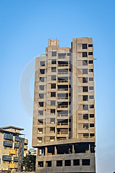 Clear blue sky behind two tall buildings in Sunlight , under construction in fast growing city of Pune, India