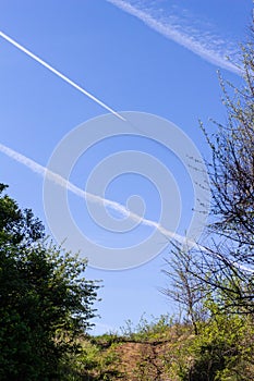 Clear blue sky with condensation trail of plane