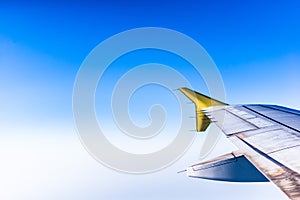 Clear blue soft sky and airplane wing through window