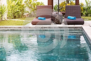 Clear blue water in swimming pool and sunbeds