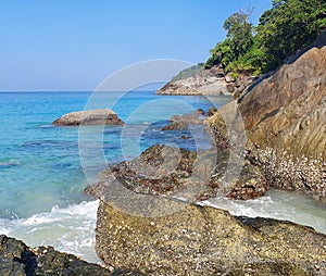 Clear blue waters and sky off a secluded beach.