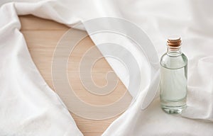 Clear Bottle of Micellar Water on Soft White Fabric, Copy Space photo