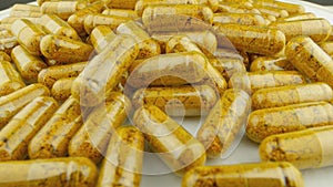 Clear capsules with pharmaceuticals rotate, creating associations with health and treatment. Turmeric and Curcumin in