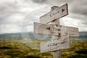 Clear the clutter text engraved on old wooden signpost outdoors in nature photo