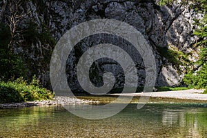 clear cold water with steep rockface while hiking in the water