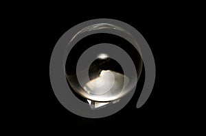 Clear crystal ball on base with black background