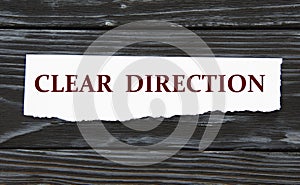 CLEAR DIRECTION - words on a torn piece of paper on a black wooden background
