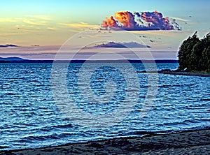 clear evening sky over a calm lake with single clouds