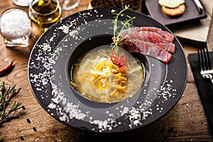 Clear Fish soup served with slices of tuna in a bowl. Delicious healthy Italian traditional food closeup served for