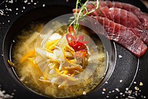 Clear Fish soup served with slices of tuna in a bowl. Delicious healthy Italian traditional food closeup served for