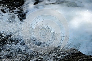 Clear, fresh stream of water splattering in a natural creek. Environmental, water conservation concept.