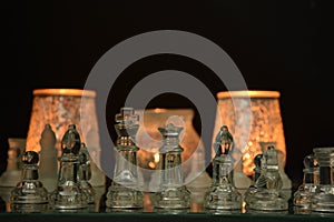 Clear glass chess pieces on a glass chessboard