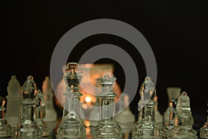 Clear glass chess pieces on a glass chessboard