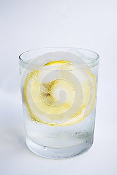 Clear glass with cold water, lemon and ice