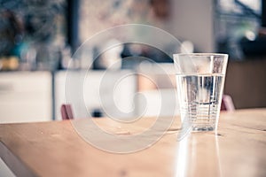 Clear glass of fresh, cold water on the kitchen table