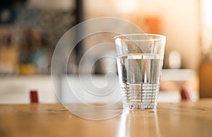 Clear glass of fresh, cold water on the kitchen table