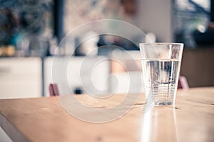 Clear glass of fresh, cold water on the kitchen table photo