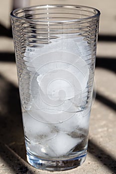 Glass of partially melted ice cubes photo