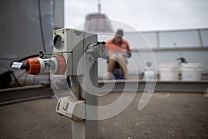 Clear high voltage powerpoint tag its attached onto BMU defocused of building maintenance unit electrician inspecting holding pape