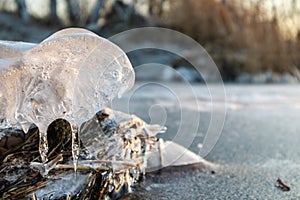 Clear ice icicle close-up sparkling on frozen lake