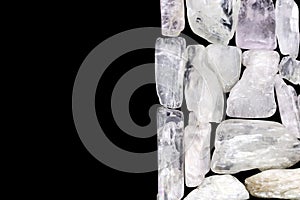 Clear kunzite heap stones texture on half black background. Place for text