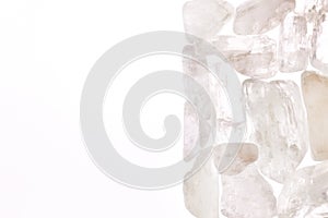 Clear kunzite heap stones texture on half white light isolated background. Place for text