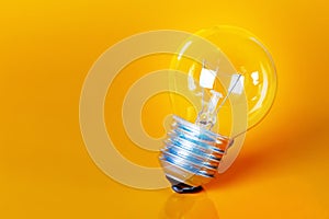 Clear Light Bulb Over Yellow Background