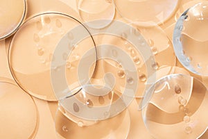 Clear magnifying lenses on bright cream background, with  water drops and shadows, abstract backdrop