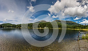 clear mountain lake while hiking in the summer panorama