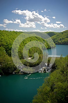 Clear mountain lakes with waterfall in forest