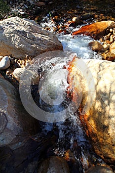 A clear mountain stream falling over smooth rocks