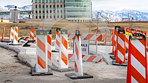 Clear Panorama Sidewalk Closed sign and road safety poles on a paved road under repair