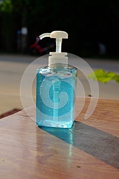 A clear plastic bottle containing a blue alcohol gel for hand cleaning to prevent coronavirus and other infections.