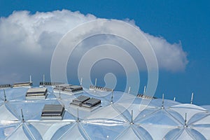 Clear plastic structured modern dome shaped public building detail. blue sky and white clouds