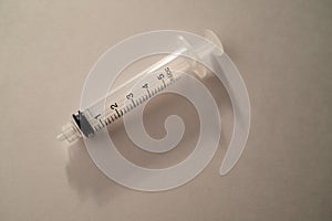 Clear Plastic Syringe on White Background with Drastic Shadows