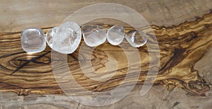 Clear quartz crystals on olive wood background