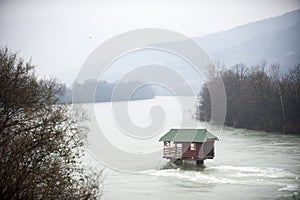 Clear river (Drina in Serbia) with a little house on a rock in mountains landscape