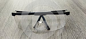 Clear safety glasses on a wooden table