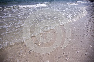 Clear sea water on white sand beach. Tropical seaside retro photo. Marine holiday. Shallow seawater. Seashore landscape.