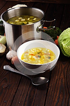 Clear soup with chicken and noodles. Broth with carrots, onions various fresh vegetables in a pot