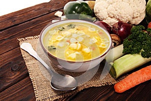 Clear soup with chicken and noodles. Broth with carrots, onions various fresh vegetables in a pot