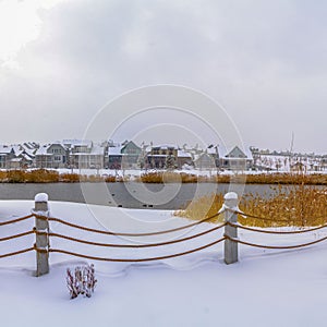 Clear Square Clubhouse overlooking lake and homes against cloudy sky on a frosty winter day